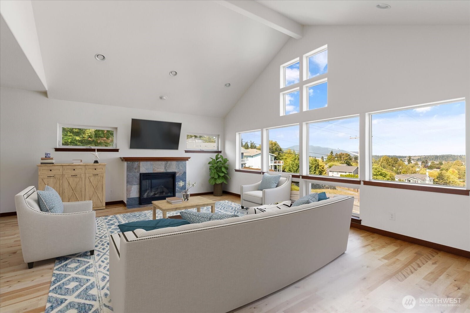 2119 20th Street Anacortes, WA 98221 - Photo 5 of 38 a living room with furniture a fireplace and a floor to ceiling window