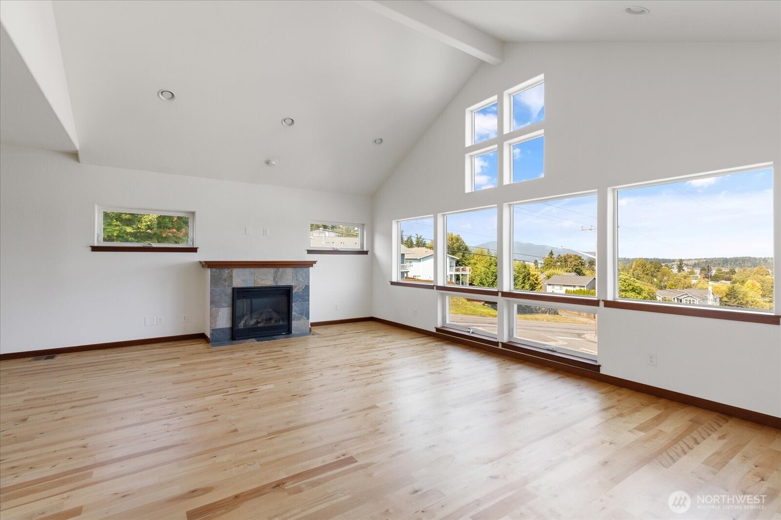 2119 20th Street Anacortes, WA 98221 - Photo 6 of 38 an empty room with wooden floor fireplace and windows