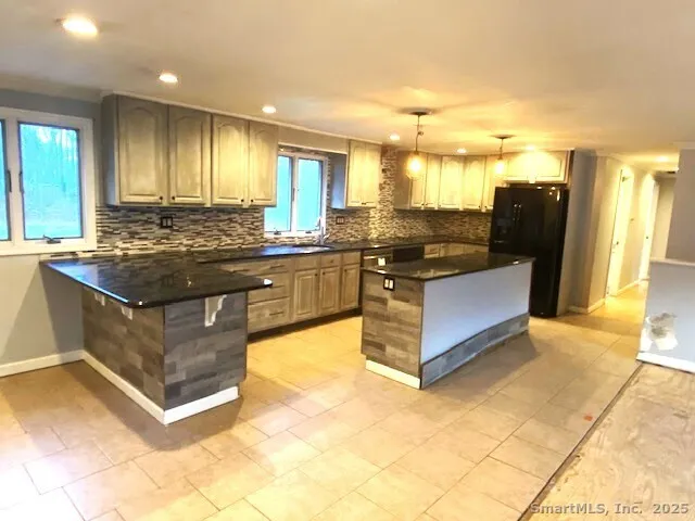 a kitchen with stainless steel appliances granite countertop a stove and a view of living room