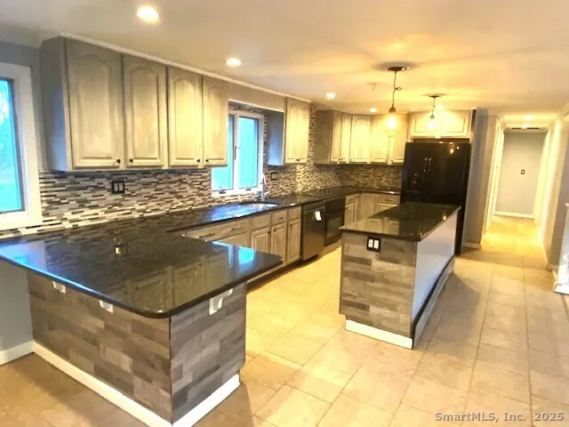 a kitchen with stainless steel appliances granite countertop a sink and a counter top space