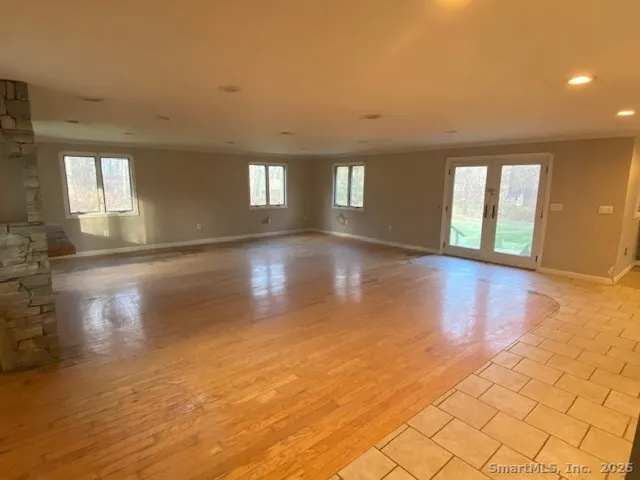 a view of empty room with window and wooden floor