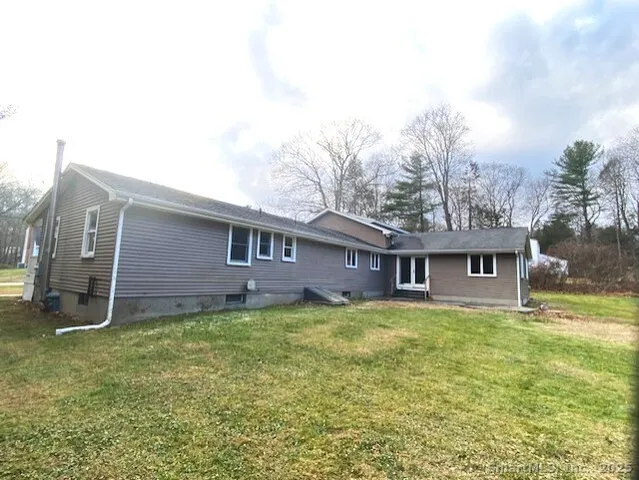 a view of a yard in front of a house with large trees