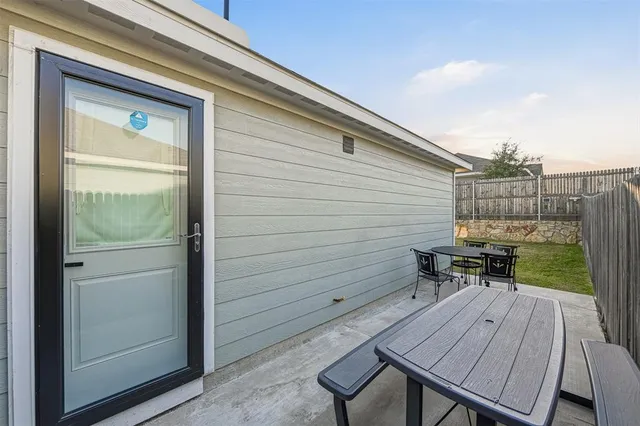 a backyard of a house with table and chairs