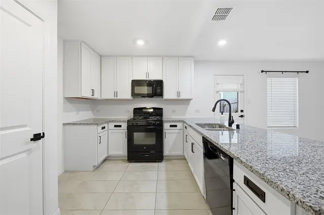 a kitchen with stainless steel appliances granite countertop a sink and cabinets