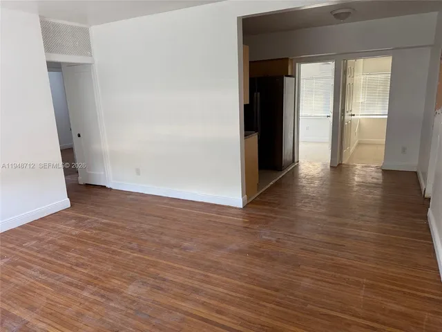 an empty room with wooden floor and closet