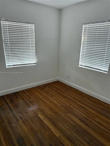 a view of a room with wooden floor and a window