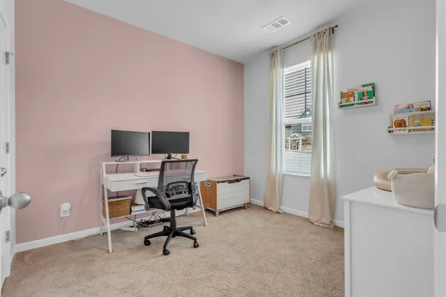 a view of a workspace with furniture and a window