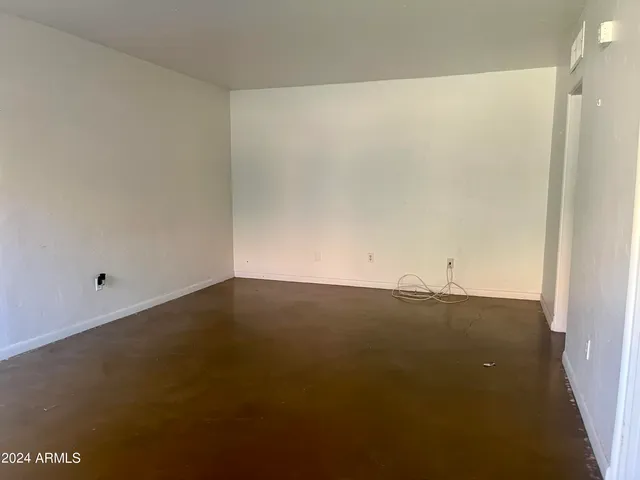 a view of an empty room and kitchen