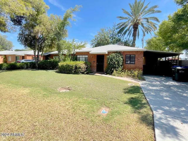 a front view of a house with yard and green space