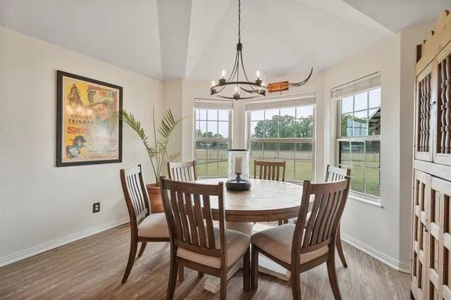 a view of a dining room with furniture large windows and wooden floor