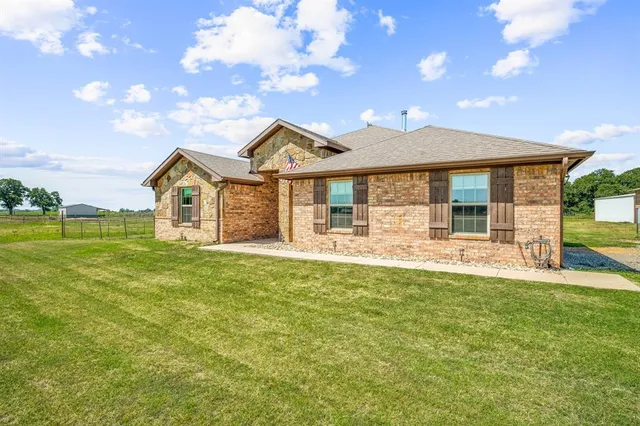 a front view of a house with a garden and yard