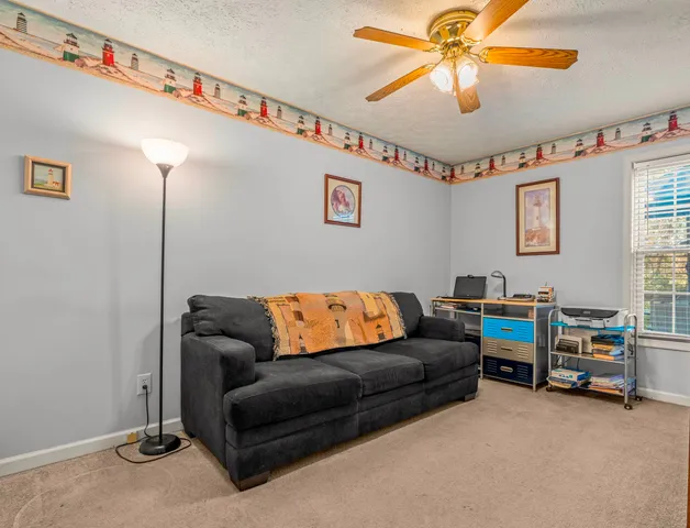 a living room with furniture a ceiling fan and a window