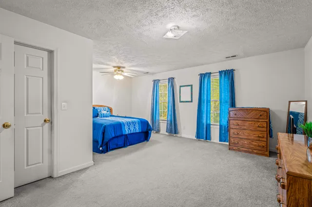 a bedroom with a large bed and a chandelier