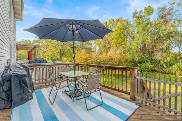 a view of a balcony with wooden floor and outdoor seating