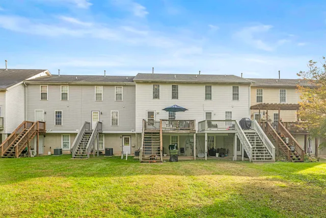 a view of a house with a big yard and large trees