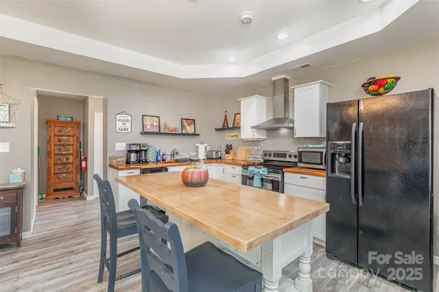 a open dining room with stainless steel appliances a table and chairs