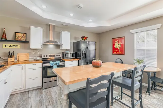a kitchen with stainless steel appliances granite countertop a table chairs and a refrigerator