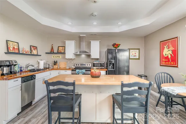 a kitchen with stainless steel appliances granite countertop a stove top oven a sink dishwasher and cabinets with wooden floor