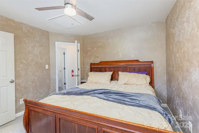 a bedroom with a bed and a painting on the wall