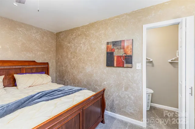 a bedroom with a bed and a flat tv screen on dresser