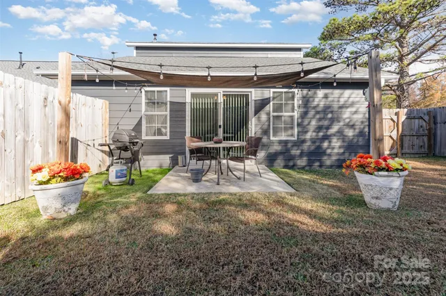 a view of a house with backyard and a tree