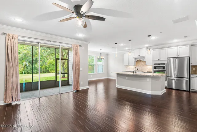 an empty room with ceiling fan and window