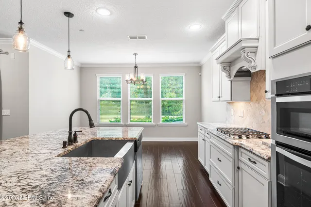 a bathroom with a sink double vanity granite tub shower and a mirror