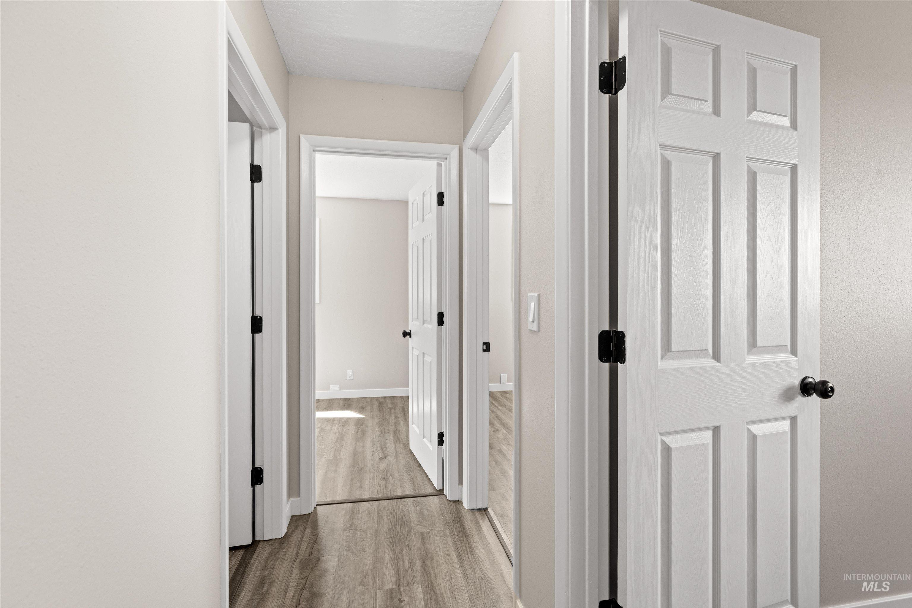 12184 Hill Road Payette, ID 83661 - Photo 20 of 35 Interior hallway with light-colored walls and wood-finish flooring