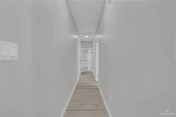 a view of a hallway with wooden floor