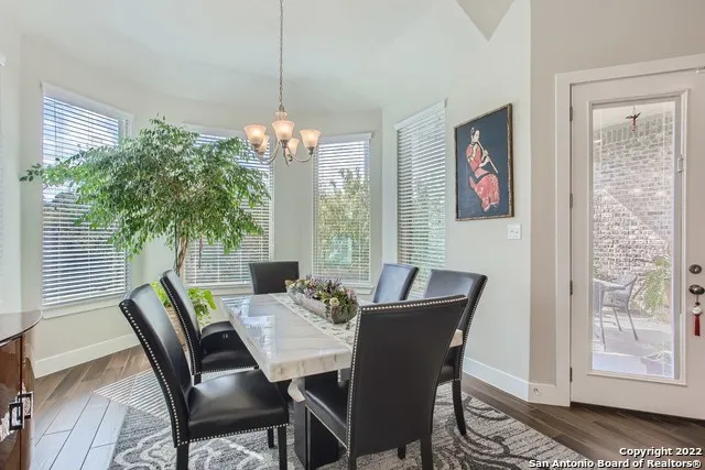 a dining room with furniture potted plants and wooden floor