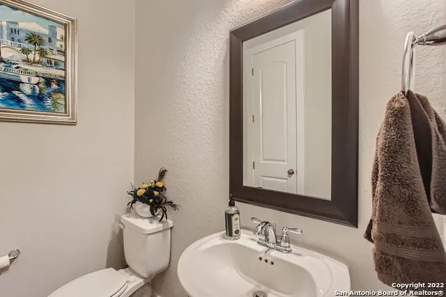 a bathroom with a toilet a sink and mirror
