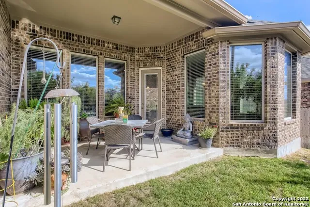 a view of patio with a table and chairs and potted plants