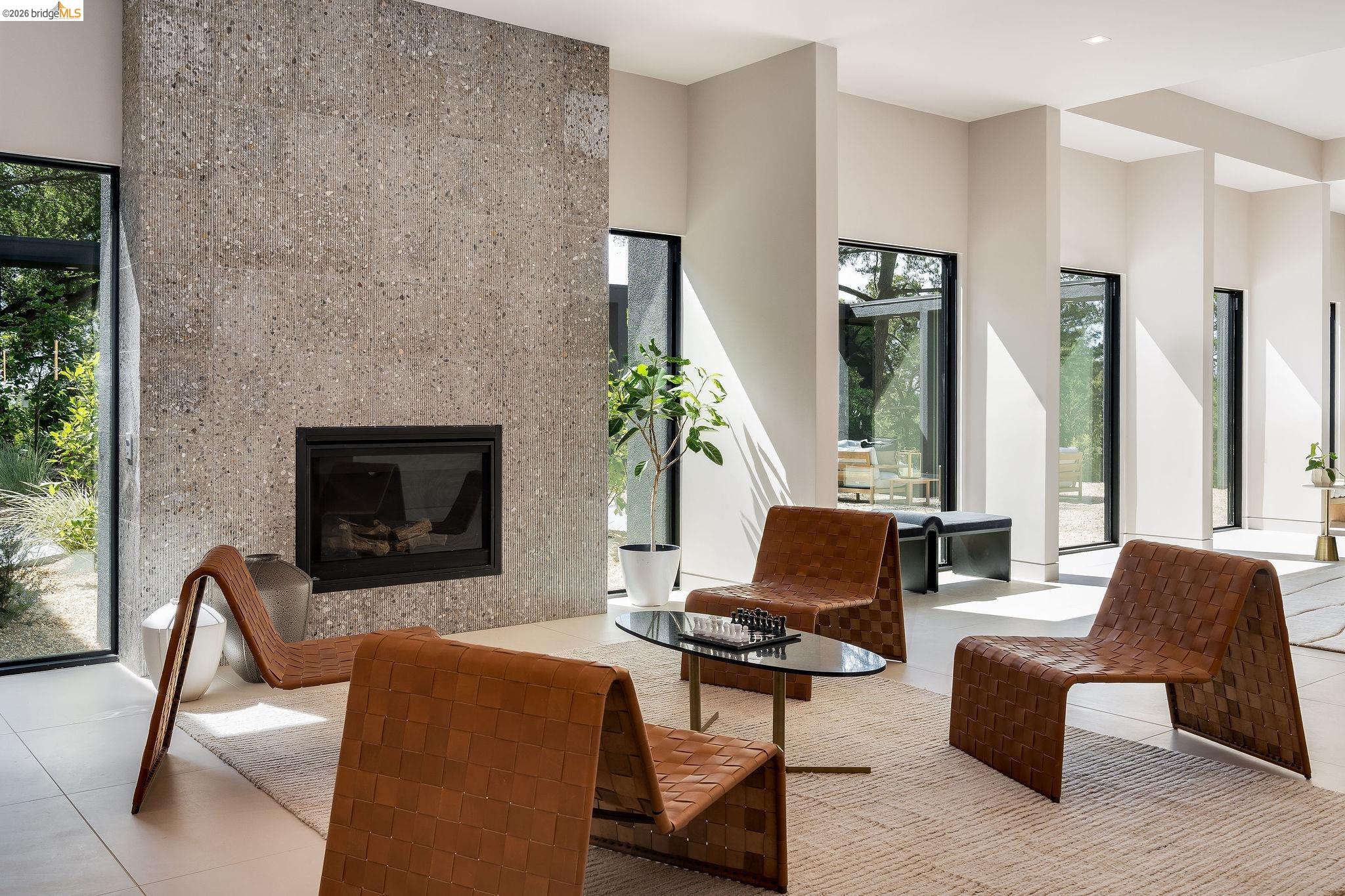 5645 Bacon Road Oakland, CA 94619 - Photo 13 of 94 Living area featuring a floor-to-ceiling fireplace with a textured stone finish and a dark metal firebox