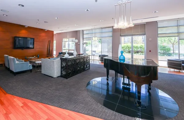 a living room with furniture a chandelier and a dining table