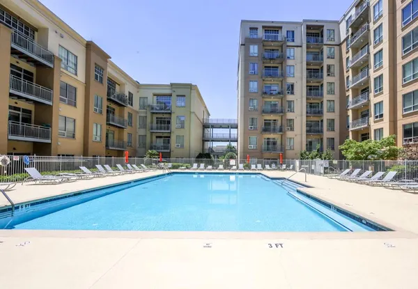 a swimming pool with outdoor seating and a building view