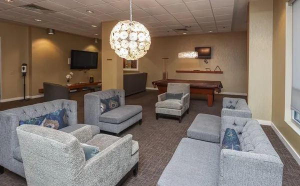 a living room with furniture a chandelier and a flat screen tv