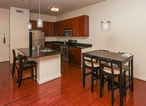 a kitchen with a table chairs refrigerator and microwave