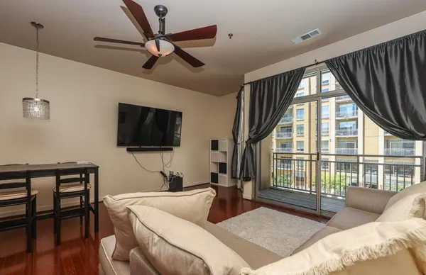 a bedroom with a bed a flat screen tv and a large window