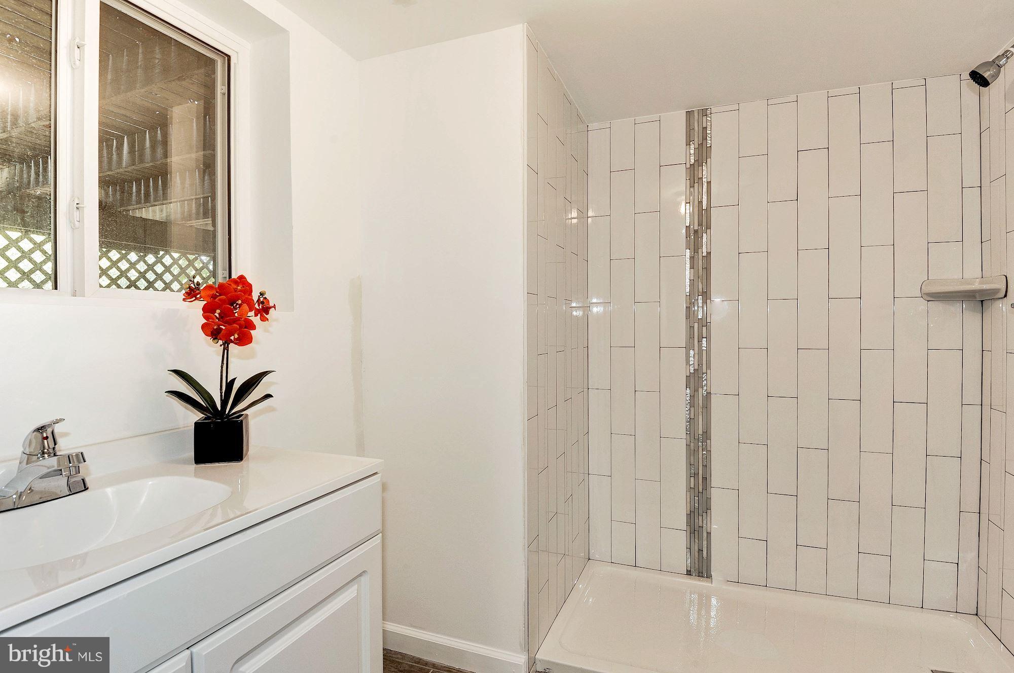 8627 Thames Street Springfield, VA 22151 - Photo 25 of 30 a bathroom with a sink a vanity and a shower