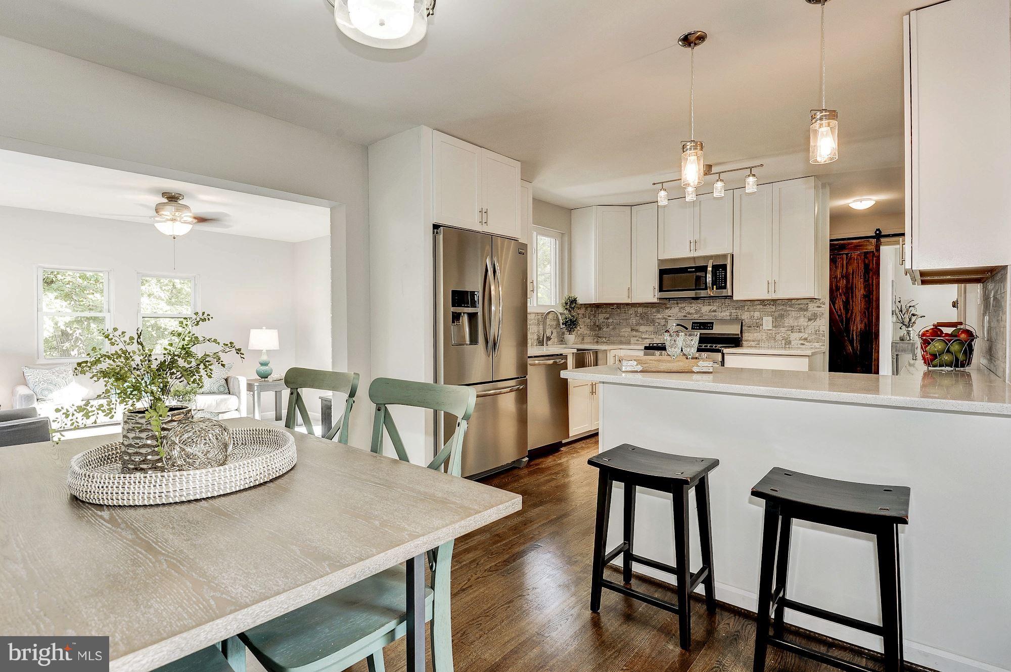 8627 Thames Street Springfield, VA 22151 - Photo 8 of 30 a kitchen with kitchen island a dining table and chairs