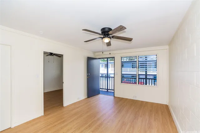 a view of an empty room with a window and wooden floor