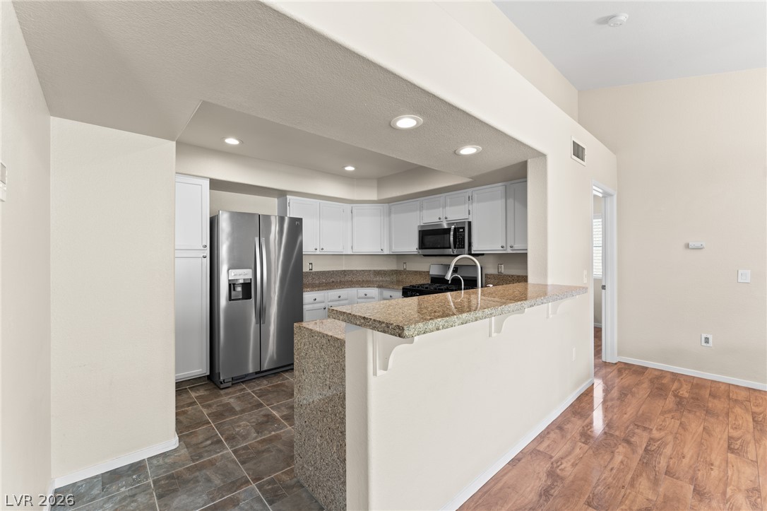 7950 West Flamingo Road, Unit 2142 Las Vegas, NV 89147 - Photo 8 of 24 Culinary delights await in this bright kitchen with premium appliances and a generous granite breakfast bar.