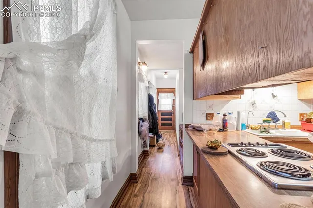 a kitchen with granite countertop a stove and a wooden floor