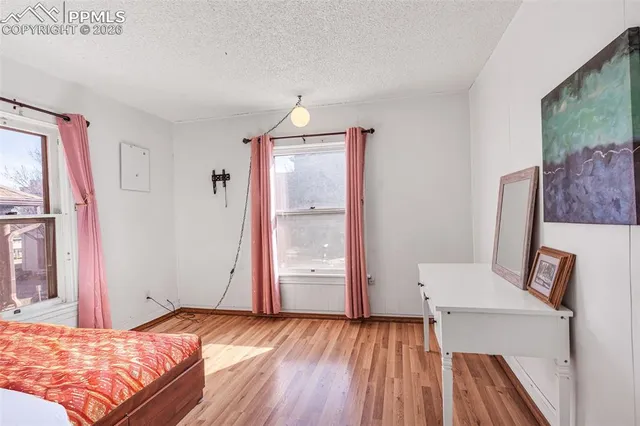 a bedroom with a bed and wooden floor