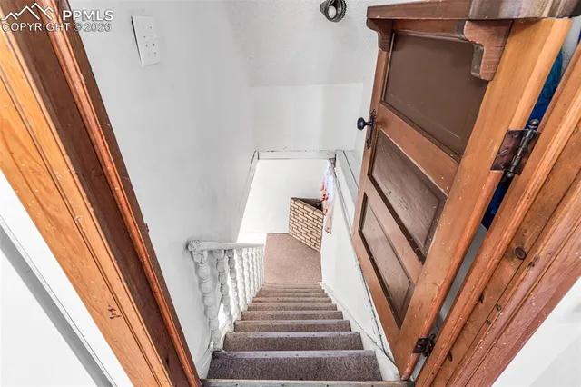 a view of staircase with white walls and a window