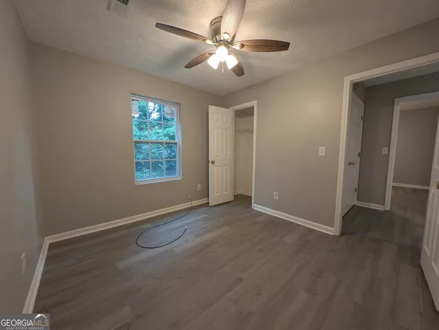an empty room with windows and fan