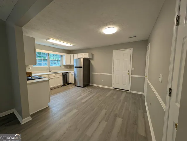 a view of open kitchen with a sink refrigerator and window