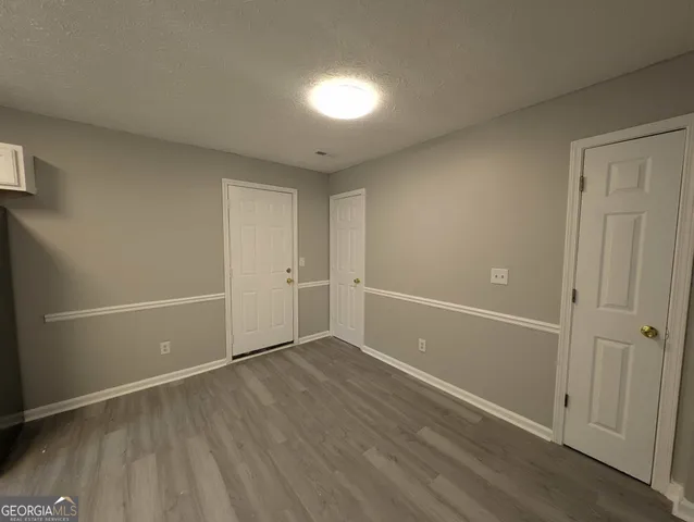 an empty room with wooden floor and shower