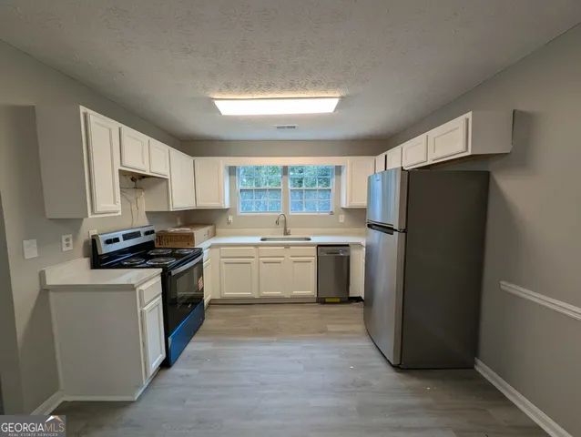 a kitchen with a refrigerator stove and sink
