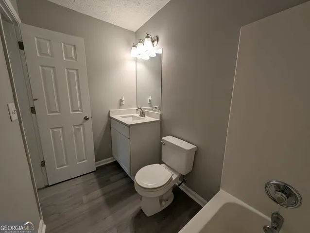 a bathroom with a toilet a sink and mirror